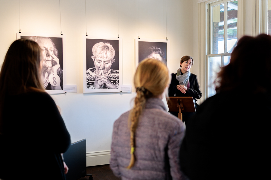 A person giving a speech at the opening of an art exhibition